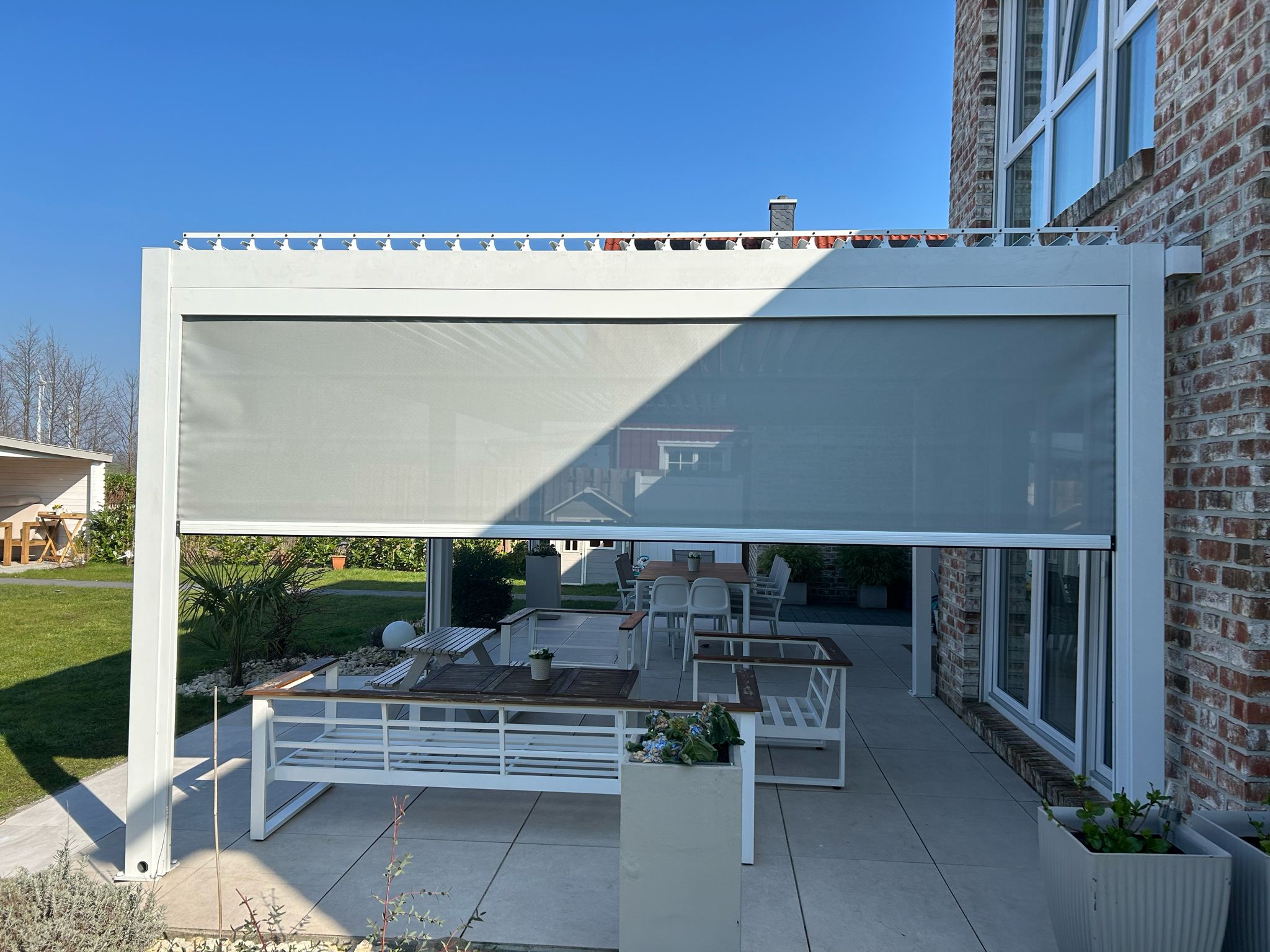 Moderne Aluminium Lamellen Überdachung in einem Garten in Bonn, perfekt auf das Haus abgestimmt